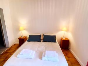 ein Schlafzimmer mit einem weißen Bett mit zwei Lampen in der Unterkunft Gîte écologique de charme avec grand jardin, proche des Alpes Mancelles, idéal famille et amis - FR-1-410-132 in Moulins-le-Carbonnel