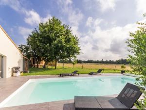 a swimming pool with two chairs and a table at Cabane au cœur du Vignoble Nantais avec piscine privative chauffée - FR-1-306-1210 in Aigrefeuille-sur-Maine