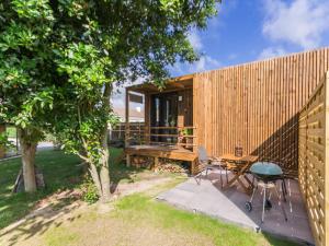 a backyard with a wooden fence and a table and chairs at Cabane au cœur du Vignoble Nantais avec piscine privative chauffée - FR-1-306-1210 in Aigrefeuille-sur-Maine