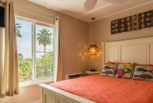 ein Schlafzimmer mit einem Bett und einem großen Fenster in der Unterkunft Sunny Side Up! - Direct OCEANFRONT Condo - End Unit - Crescent Beach, Saint Augustine Florida in Crescent Beach + 68 Fotos