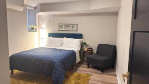 a bedroom with a bed and a chair at Luxury 2-Bedroom Designer Suite Richmond Hill Lake Wilcox in Richmond Hill