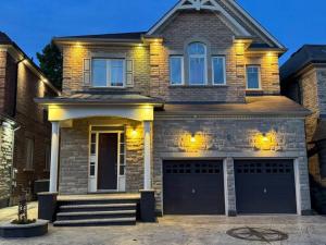 a brick house with two garage doors in front at Luxury 2-Bedroom Designer Suite Richmond Hill Lake Wilcox in Richmond Hill