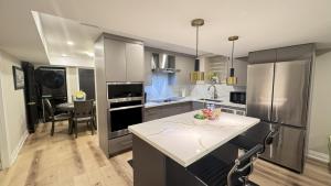 a kitchen with stainless steel appliances and a table at Luxury 2-Bedroom Designer Suite Richmond Hill Lake Wilcox in Richmond Hill