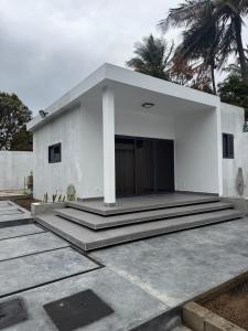una casa blanca con escalones delante en Built2Last Beach Houses, en Xai-Xai