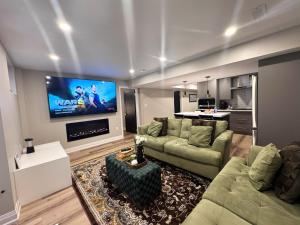 a living room with a couch and a flat screen tv at Luxury 2-Bedroom Designer Suite Richmond Hill Lake Wilcox in Richmond Hill