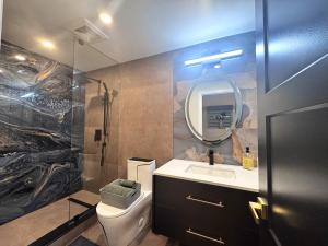 a bathroom with a toilet and a sink and a mirror at Luxury 2-Bedroom Designer Suite Richmond Hill Lake Wilcox in Richmond Hill +57 photos