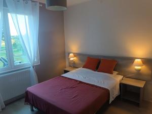 a bedroom with a bed with red pillows and a window at Gîte spacieux avec salle de jeux, tennis et cheminée, idéal pour familles et amis jusqu'à 15 pers. - FR-1-410-223 in Saint-Jean-de-la-Motte