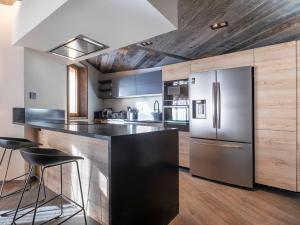 eine Küche mit Edelstahlkühlschrank und Holzschränken in der Unterkunft Appartement d'exception 7 pièces pour 12 pers, espace bien-être à Avoriaz - FR-1-314-102 in Avoriaz