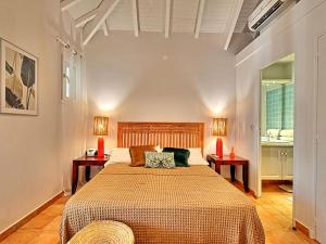 a bedroom with a large bed with two night stands at Charmante Villa "Coquelicot" à Orient Baie, Proche Plage et Commerces, Confort et Détente Garantis - FR-1-734-10 in Orient Bay