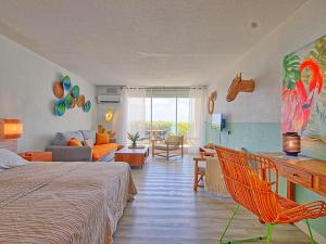 Un dormitorio con una cama y una sala de estar. en Sweet Candy - Studio Spacieux avec Vue Mer à Baie Orientale - FR-1-734-31, en Cul de Sac 23 fotos más