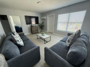 a living room with a blue couch and a tv at Barefoot Bay Resort Motel in Clearwater Beach