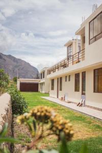ein Gebäude mit einem Garten mit Blumen im Vordergrund in der Unterkunft Hotel Casa Suite Inka in Ollantaytambo