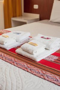 eine Gruppe Handtücher auf dem Bett in der Unterkunft Hotel Casa Suite Inka in Ollantaytambo
