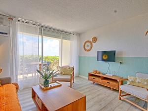 Una sala de estar con un sofá y un televisor. en Sweet Candy - Studio Spacieux avec Vue Mer à Baie Orientale - FR-1-734-31, en Cul de Sac