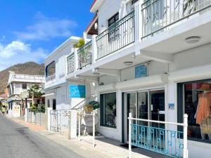 ein weißes Gebäude mit Fenstern und Balkonen auf einer Straße in der Unterkunft Studio cosy à 2 min de la plage, Grand Case - FR-1-734-36 in Grand Case