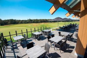 une terrasse avec des tables et des chaises sur un terrain de golf dans l'établissement Boutique Hotel de Zeuve Meeren, à Someren