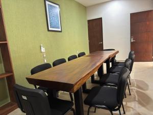 Aeropuerto Express Huatulco في Bahías de Huatulco: قاعة المؤتمرات مع طاولة وكراسي خشبية طويلة