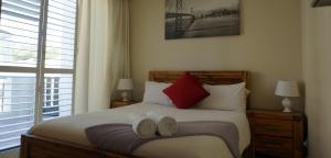 a bedroom with a bed with two mitts on it at Seaside apartment - Big Bay beach in Cape Town +16 photos
