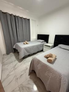 ein Schlafzimmer mit zwei Betten mit Handtüchern darauf in der Unterkunft Alojamiento Yvoty in Paso de los Libres