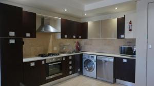 a kitchen with a washing machine and a washer at Seaside apartment - Big Bay beach in Cape Town