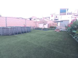 a small backyard with a green yard with a fence at Casa El Obrador in Arguedas