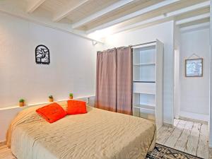 - une chambre avec un lit et deux oreillers orange dans l'établissement Superbe appartement 2 chambres à Anse Marcel, 400m des plages, activités nautiques incluses - FR-1-734-44, à Anse-Marcel