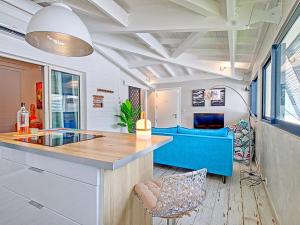une cuisine avec un comptoir et un canapé bleu dans l'établissement Superbe appartement 2 chambres à Anse Marcel, 400m des plages, activités nautiques incluses - FR-1-734-44, à Anse-Marcel