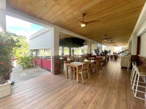 un restaurant avec du parquet, des tables et des chaises dans l'établissement Studio cosy à Anse Marcel avec terrasse et climatisation - FR-1-734-47, à Anse-Marcel