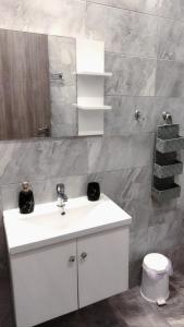 a bathroom with a white sink and a mirror at Mirsini Apartments in Agios Georgios