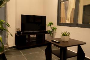 a living room with a flat screen tv and a table at Villa EN 22 in Galle