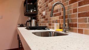 - un comptoir de cuisine avec un évier et un mur en briques dans l'établissement Villa Guarumo, à Santa Eulalia 13 autres photos