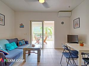 a living room with a couch and a table at Appartement cosy à Grand Case, proche plage, piscine, parking et Wi-Fi inclus - FR-1-734-77 in Marigot