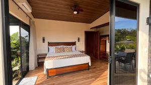 une chambre avec un lit et un balcon dans l'établissement Villa Guarumo, à Santa Eulalia