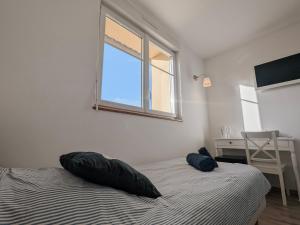 - une chambre avec 2 oreillers sur un lit et une fenêtre dans l'établissement Maeli - FR-1-591-707, à Fontguenand