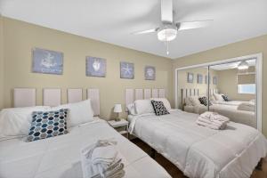 a bedroom with two beds and a mirror at Holiday Villas II Unit 301 in Clearwater Beach