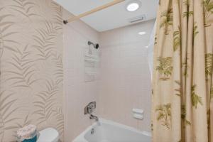 a bathroom with a shower curtain with palm trees on it at Holiday Villas II Unit 301 in Clearwater Beach +38 photos