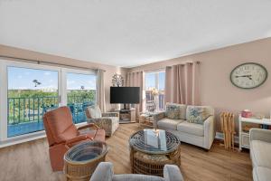 a living room with a clock on the wall at Holiday Villas II Unit 301 in Clearwater Beach