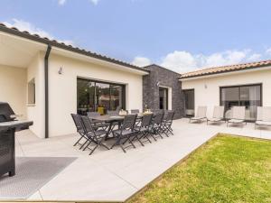 a patio with a table and chairs on it at Gîte spacieux avec jardin, spa, babyfoot et parking privé - FR-1-306-1292 in La Haie-Fouassière