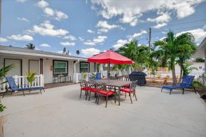 a patio with a table and chairs and a red umbrella at Park Shore Suites Unit 6 in St. Pete Beach