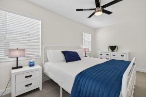 a white bedroom with a bed and a ceiling fan at Park Shore Suites Unit 6 in St. Pete Beach