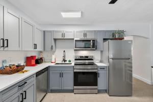 a kitchen with white cabinets and a stainless steel refrigerator at Park Shore Suites Unit 6 in St. Pete Beach