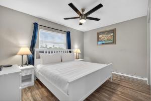 圣徒皮特海滩Sunset Beach Suites Unit 10的卧室配有白色的床和吊扇