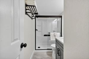 a white bathroom with a shower and a toilet at Sunset Beach Suites Unit 1 in St. Pete Beach +42 photos