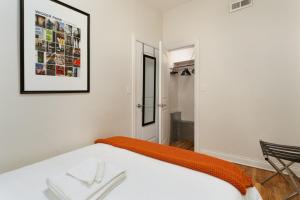 a bedroom with a bed with an orange blanket at Flexhome Wicker Park - Stylish 2BR - Sleeps 6 in Chicago
