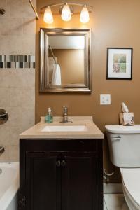 a bathroom with a sink and a toilet and a mirror at Flexhome Wicker Park - Stylish 2BR - Sleeps 6 in Chicago +9 photos