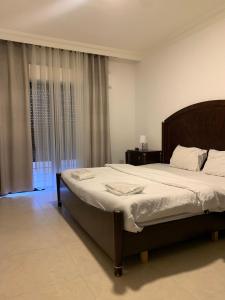 ein Schlafzimmer mit einem großen Bett und einem Fenster in der Unterkunft Luxurious 3 Bedroom Apartment in Heart of Amman in Rujm ash Sharāʼirah