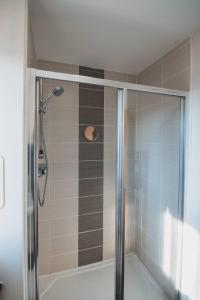 a shower with a glass door in a bathroom at Top-Floor 2-Bed Near Braehead in Renfrew