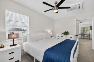 a white bedroom with a bed and a ceiling fan at Park Shores Suites Unit 9 in St Pete Beach