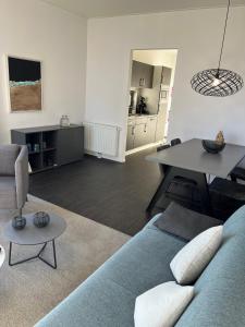 a living room with a blue couch and a table at Ferienhaus 55 am Wasser Olburgen - perfekt für Familien - mit Freibad, Sauna, Restaurant und Spielplatz in Olburgen