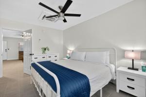 圣徒皮特海滩Park Shore Suites Unit 7的一间带床和吊扇的白色卧室